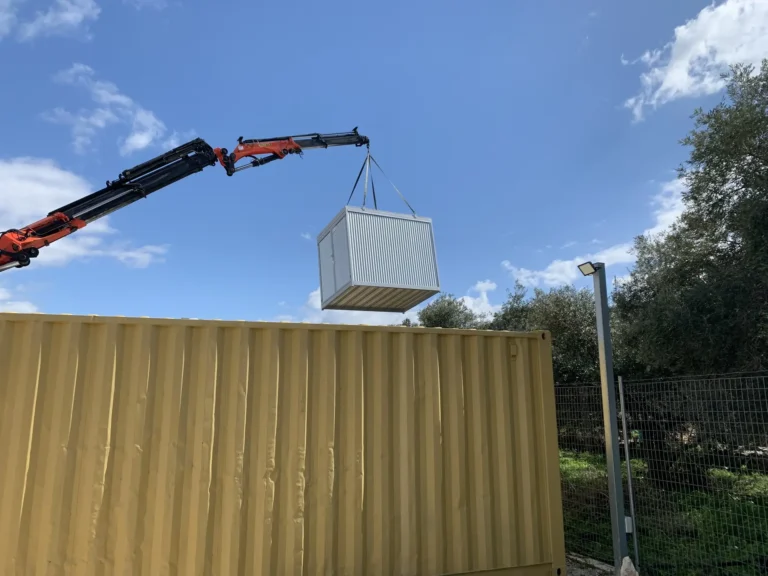 crane lifting shipping container for construction site rental in Chania Crete